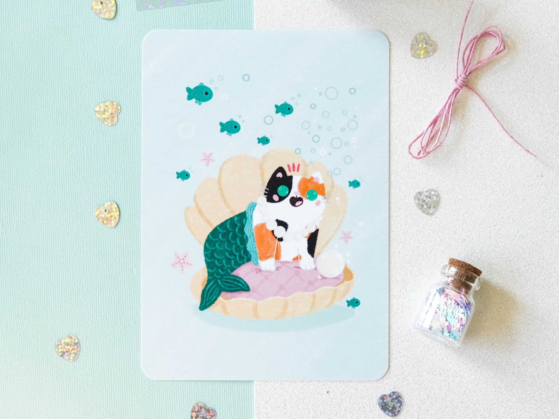 Illustration format carte A6 avec un chat calico sirène dans un coquillage avec une perle parfaite pour offrir ou décorer son intérieur