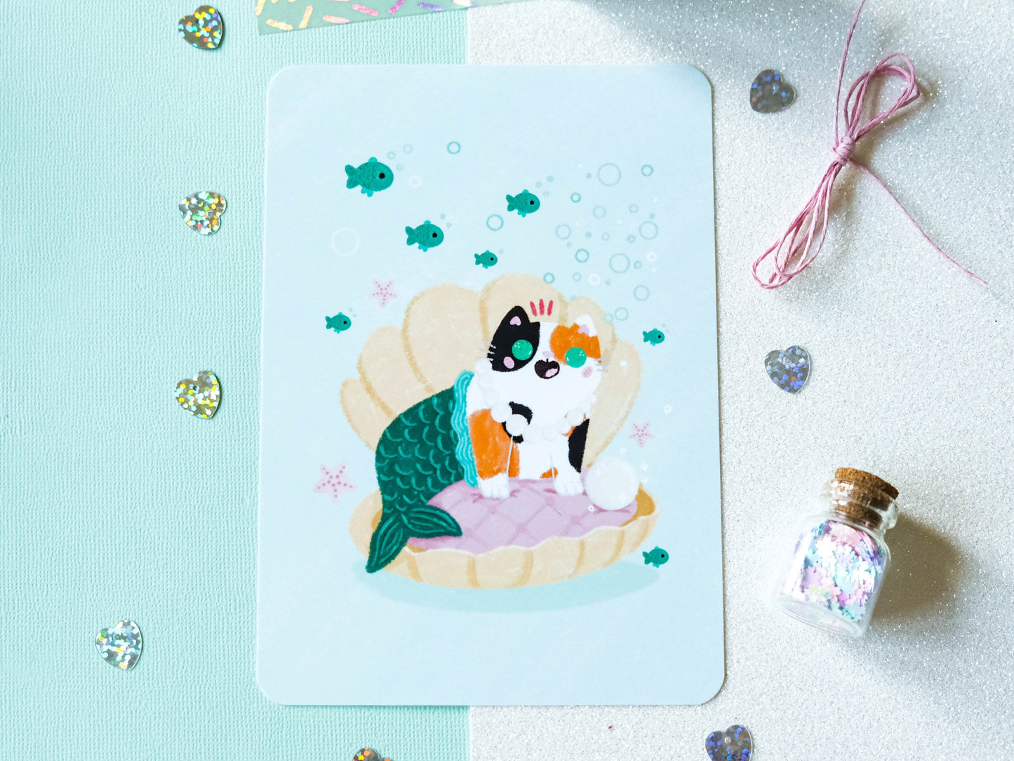 Illustration format carte A6 avec un chat calico sirène dans un coquillage avec une perle parfaite pour offrir ou décorer son intérieur